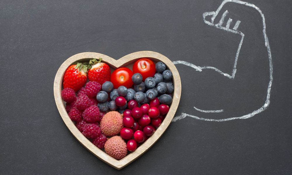 heart shaped bowl of berries with chalk bicep